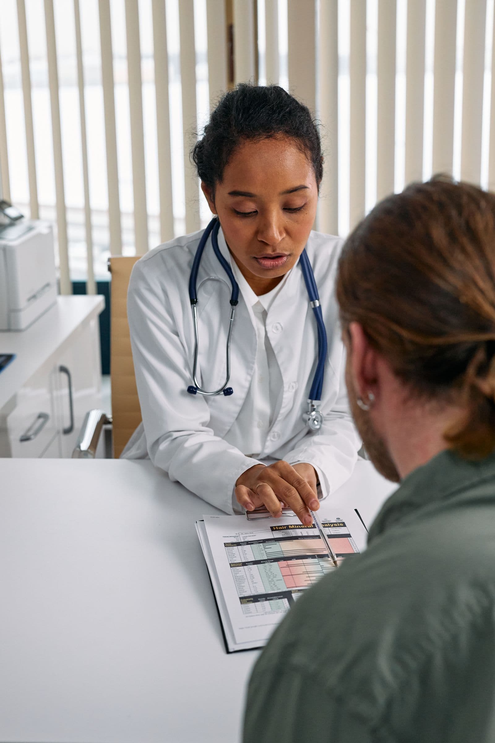 Doctor walking a patient through a chart at her desk