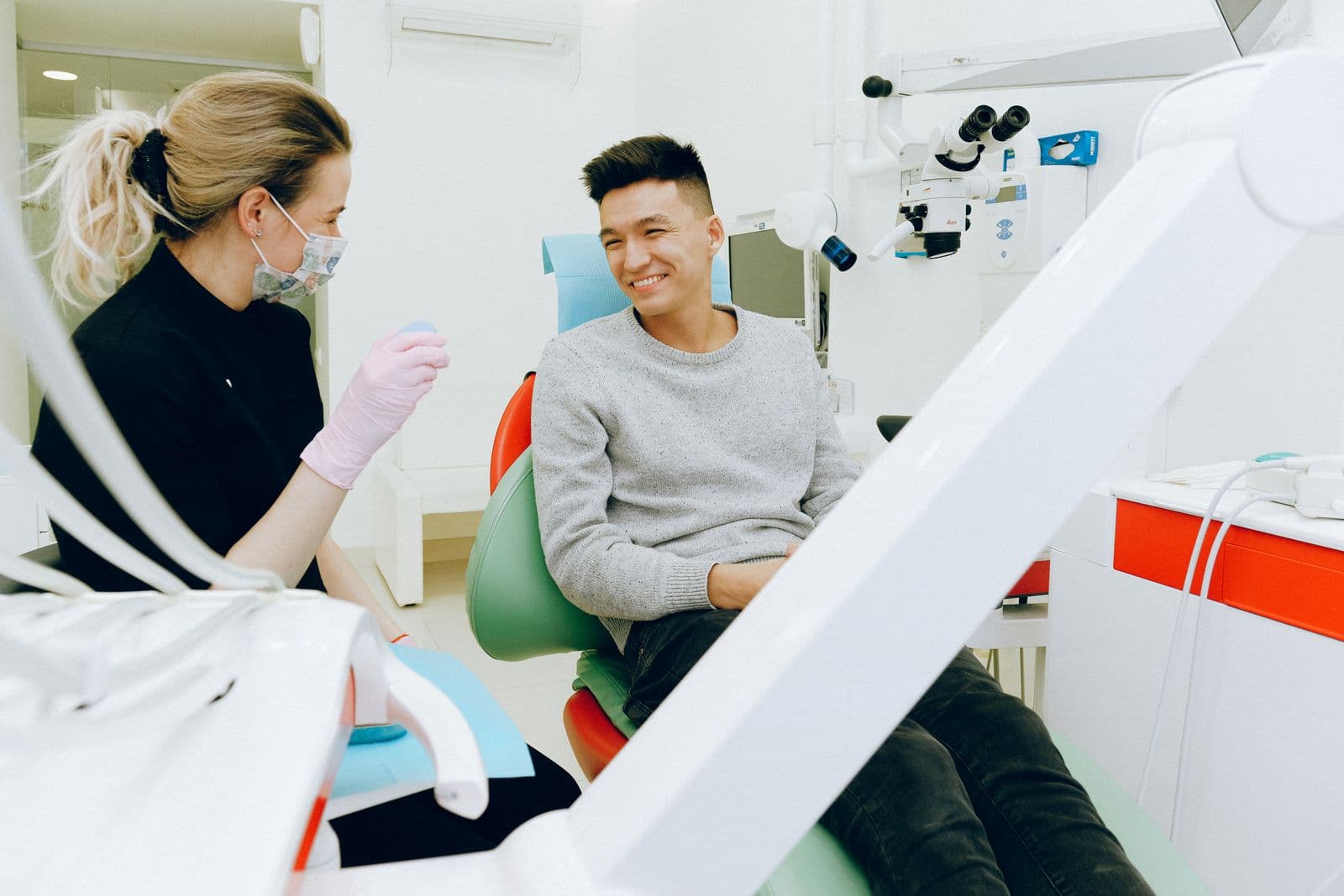 Dentist talking with a smiling patient in the chair