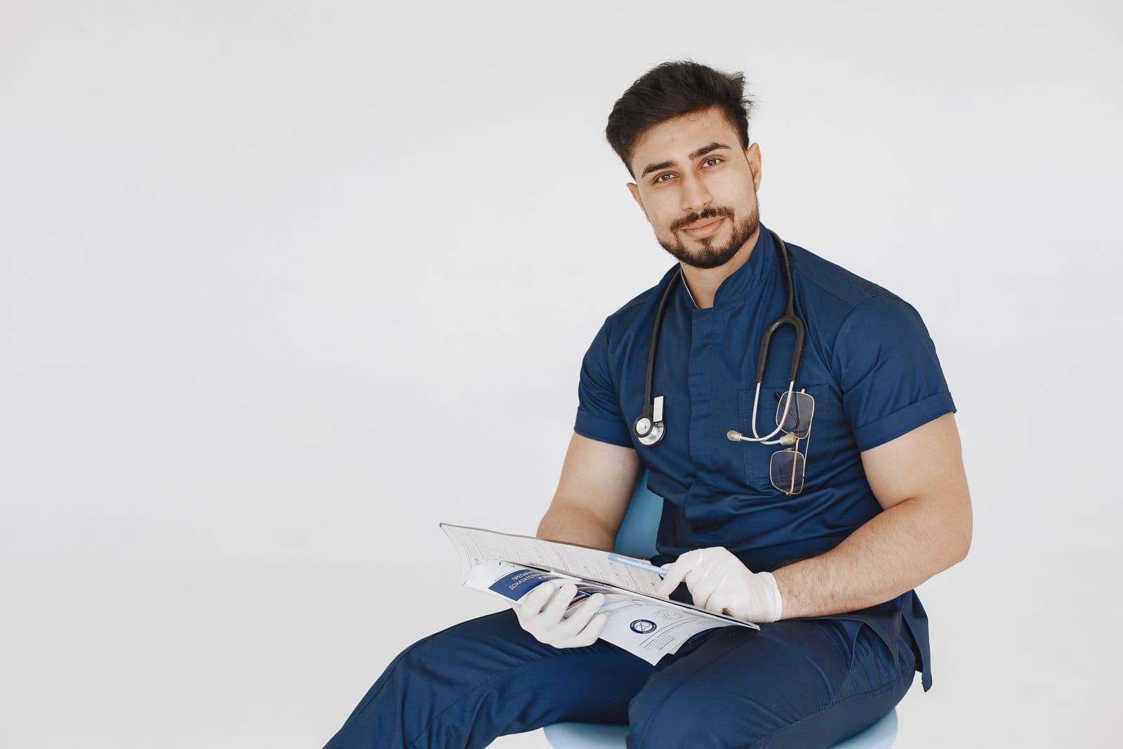 Doctor in scrubs reviewing notes on a tablet